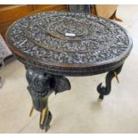 EARLY 20TH CENTURY EASTERN TABLE WITH CARVED DECORATION ON SHAPED ELEPHANT SUPPORTS,