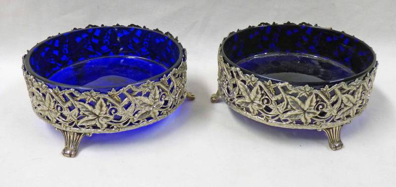 PAIR OF CIRCULAR SILVER DISHES WITH PIERCED LEAF WORK, DECORATION & BLUE GLASS LINERS,