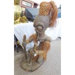 LARGE AFRICAN 20TH CENTURY CARVED KNEELING FIGURE OF A WOMAN WITH WOVEN AND FRINGED GRASS SKIRT,