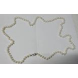LONG STRING OF CULTURED PEARLS ON PEARL SET CLASP MARKED SILVER,