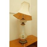 19TH CENTURY PARAFFIN LAMP CONVERTED TO A TABLE LAMP WITH BRASS SUPPORTS A DECORATED GLASS COLUMN &