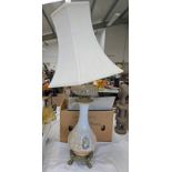 19TH CENTURY PARAFFIN LAMP CONVERTED TO A TABLE LAMP WITH BRASS SUPPORTS A DECORATED GLASS COLUMN &
