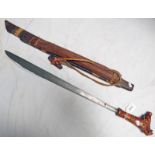 A MANDAU WITH CARVED WOODEN HILT AND HEAVY BLADE WITH BRASS DOT DECORATION 63CM LONG,