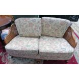 EARLY 20TH CENTURY WALNUT FRAMED BERGERE SETTEE ON QUEEN ANNE SUPPORTS