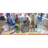 A SELECTION OF GLASS BOTTLES AND POTTERY WHISKY FLAGONS TO INCLUDE LAMBS 100 NAVY RUM,