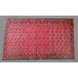 RED GROUND BALUCHI RUG WITH ALL OVER BUKHARA DESIGN 190 X 111CM