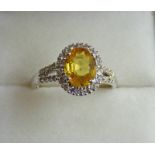 A YELLOW SAPPHIRE AND DIAMOND CLUSTER RING,