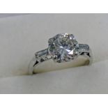 18CT GOLD SET DIAMOND SOLITAIRE RING WITH BAGUETTE CUT DIAMOND SET SHOULDERS,