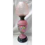 19TH CENTURY PINK GLASS OIL LAMP WITH FLORAL ENAMEL DECORATION ON A BLADE CIRCULAR BASE WITH A PINK