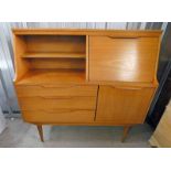 TEAK CABINET WITH FALL FRONT OVER 3 DRAWER & PANEL DOOR.