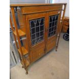 OAK ARTS & CRAFTS STYLE CABINET WITH 2 LEADED GLASS DOORS ON SHAPED SUPPORTS CIRCA 1920