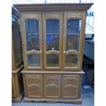 OAK CABINET WITH 2 GLASS PANEL DOORS OPENING TO SHELVED INTERIOR OVER 3 PANEL DOORS,