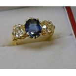 18CT GOLD SAPPHIRE & DIAMOND 3 - STONE RING. THE OVAL SAPPHIRE OF APPROX 1.