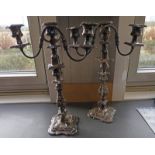 PAIR OF SILVER PLATED 3-BRANCH CANDELABRA WITH ACANTHUS LEAF DECORATION ON SHAPED SQUARE BASES -
