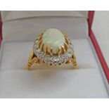 18CT GOLD OVAL OPAL & DIAMOND SET CLUSTER RING, THE DIAMONDS APPROX 0.80 CARATS IN TOTAL.