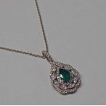 18CT WHITE GOLD EMERALD & DIAMOND PENDANT ON AN 18CT GOLD CHAIN.