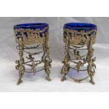 PAIR OF WHITE METAL SALTS WITH CHERUB & PIERCED DECORATION & BLUE GLASS LINERS