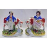 PAIR OF 19TH CENTURY STAFFORDSHIRE POTTERY FIGURES OF FARMING COUPLE WITH COWS - 17.