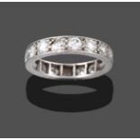 A Diamond Eternity Ring, the round brilliant cut diamonds in white claw settings, with engraved