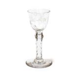 A Wine Glass, circa 1780, the rounded funnel bowl engraved with a flower on a knopped faceted