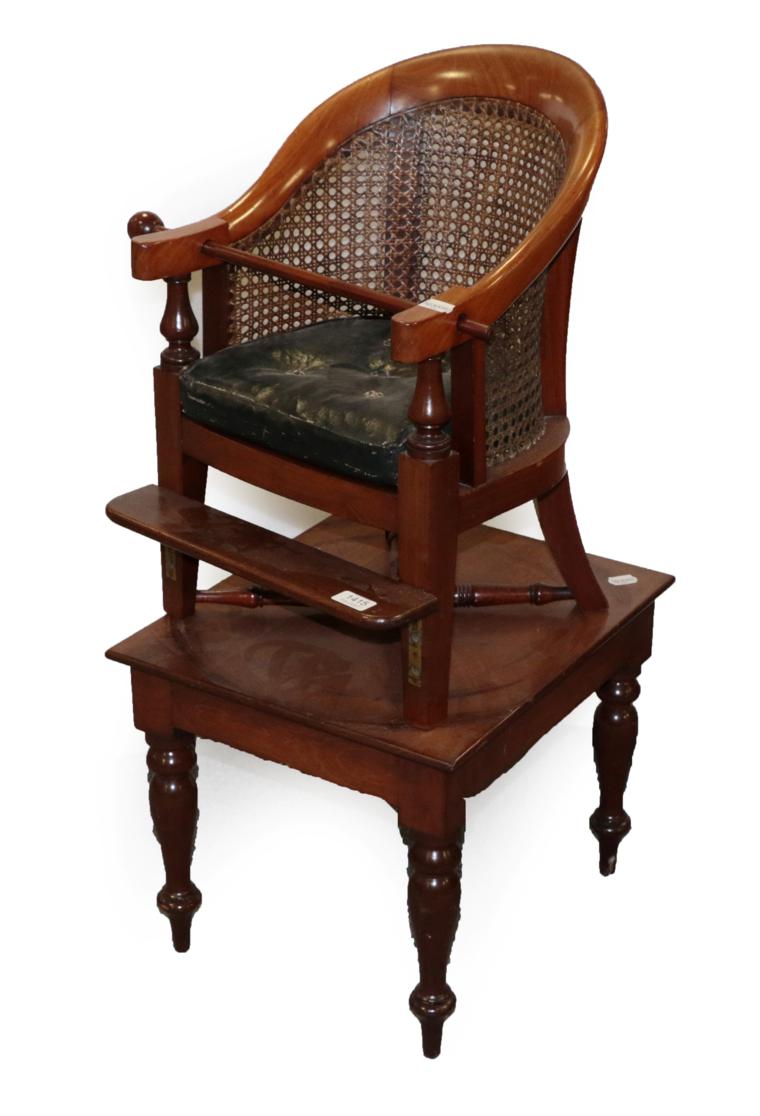 A Victorian Child's Highchair, circa 1870, with caned back support and seat above a squab cushion