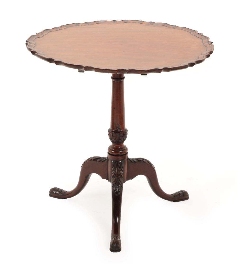 A George III Style Mahogany Pie Crust Tripod Table, the flip-top on a baluster acanthus carved