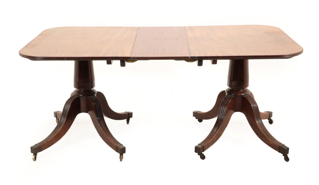 A George III Mahogany Twin-Pillar Dining Table, late 18th century, with one additional leaf and