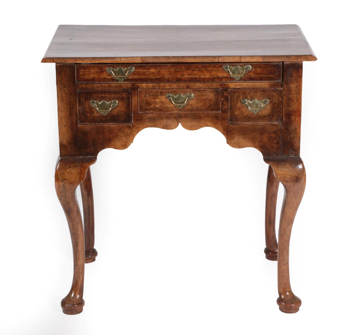 A Walnut and Feather Banded Dressing Table, the quarter-veneered top above a long frieze drawer with