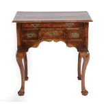 A Walnut and Feather Banded Dressing Table, the quarter-veneered top above a long frieze drawer with