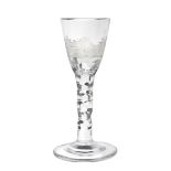 A Wine Glass, circa 1780, the rounded funnel bowl engraved with a village scene on a faceted stem,