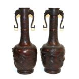 A Pair of Japanese Bronze Bottle Vases, Meiji period, with mask and loop handles on stiff leaf