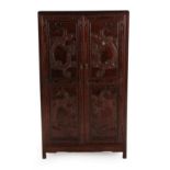 A Chinese Hardwood Cupboard, 20th century, the two twin-panelled doors carved with dragons enclosing