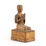 A Gilt Metal Figure of Buddha, Thai, 19th century, the kneeling figure with hands at prayer, on a