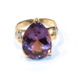 A pear shaped amethyst solitaire ring with diamond set shoulders, finger size I1/2. Gross weight 3.6