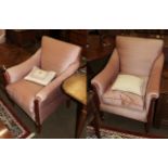 A pair of Edwardian mahogany and satinwood strung armchairs with pink silk upholstery, raised on