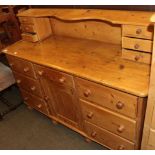 An early 20th century pine dresser with raised superstructure containing two banks of three small