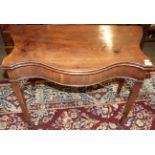 An early 19th century Chippendale style serpentine fronted mahogany fold over tea table, with fret