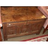 An early 18th century oak coffer, with three carved panels, raised on stile feet