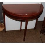 A Georgian style mahogany demi-lune fold over card table, on tapered legs and spade feet