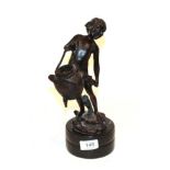 A bronze figure of a child carrying a basket, raised on a marble plinth, signed