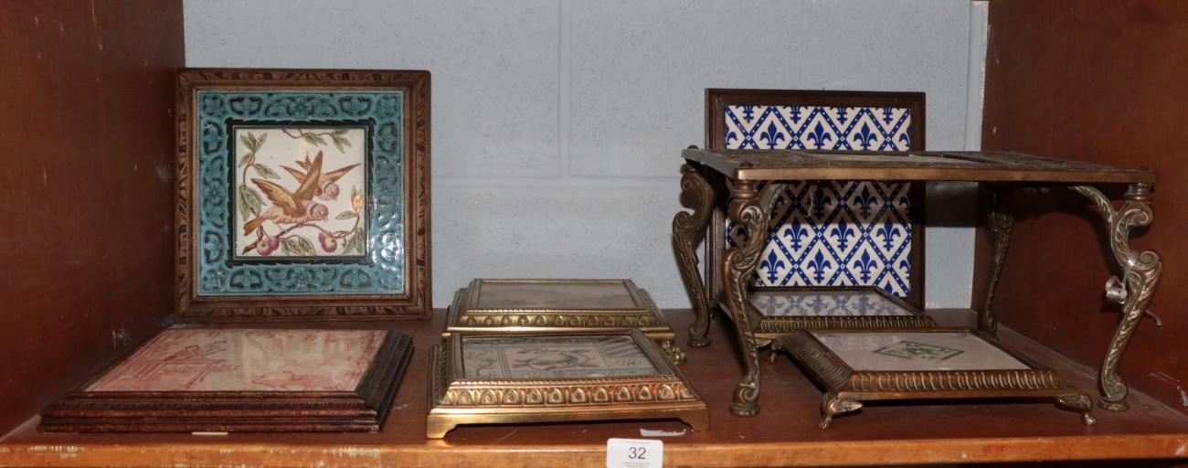 A matched pair of late Victorian brass mounted tile teapot/trivet stands, green and yellow floral