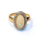 An 18 carat gold opal and diamond cluster ring, finger size K1/2. Gross weight 4.6 grams.