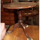 A George III mahogany tilt top tripod table raised on pad feet