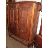 A late 19th/early 20th century oak two door cupboard, raised on bobbin turned legs and bun feet
