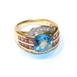 A 14 carat gold blue topaz within a border of pink stones ring, finger size L1/2. Gross weight 8.6