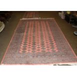 Bokhara Carpet, the soft coral pink field with four columns of guls enclosed by multiple borders,