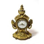 An ormolu mantel timepiece, circa 1900, urn shaped finial, side rams head masks and swag decoration,