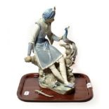 A Lladro model of an Indian figure and a peacock
