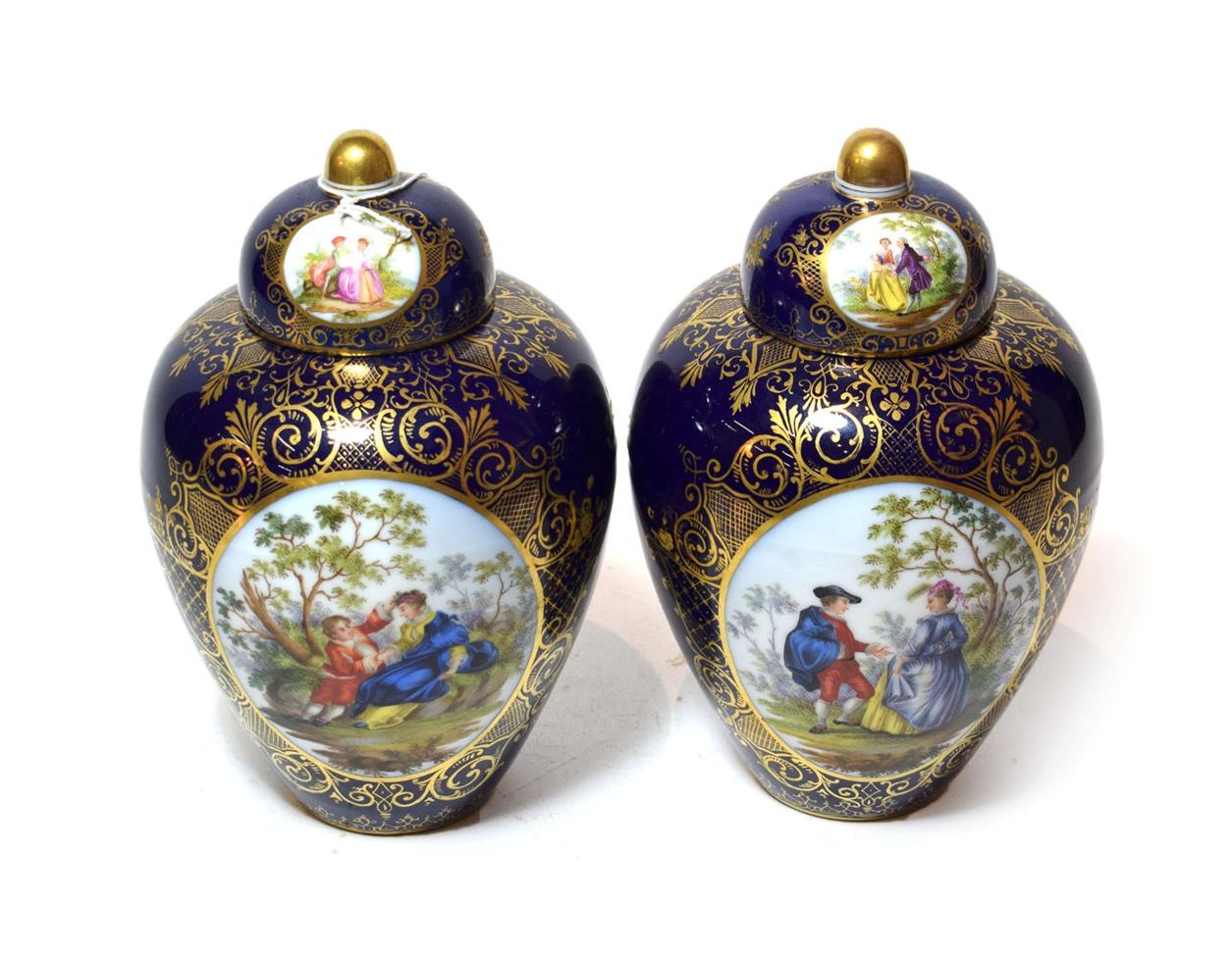 A pair of Dresden vases and covers, central painted panels of flowers and courting couples to the