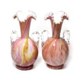 A pair of twin-handled pink marbled glass vases
